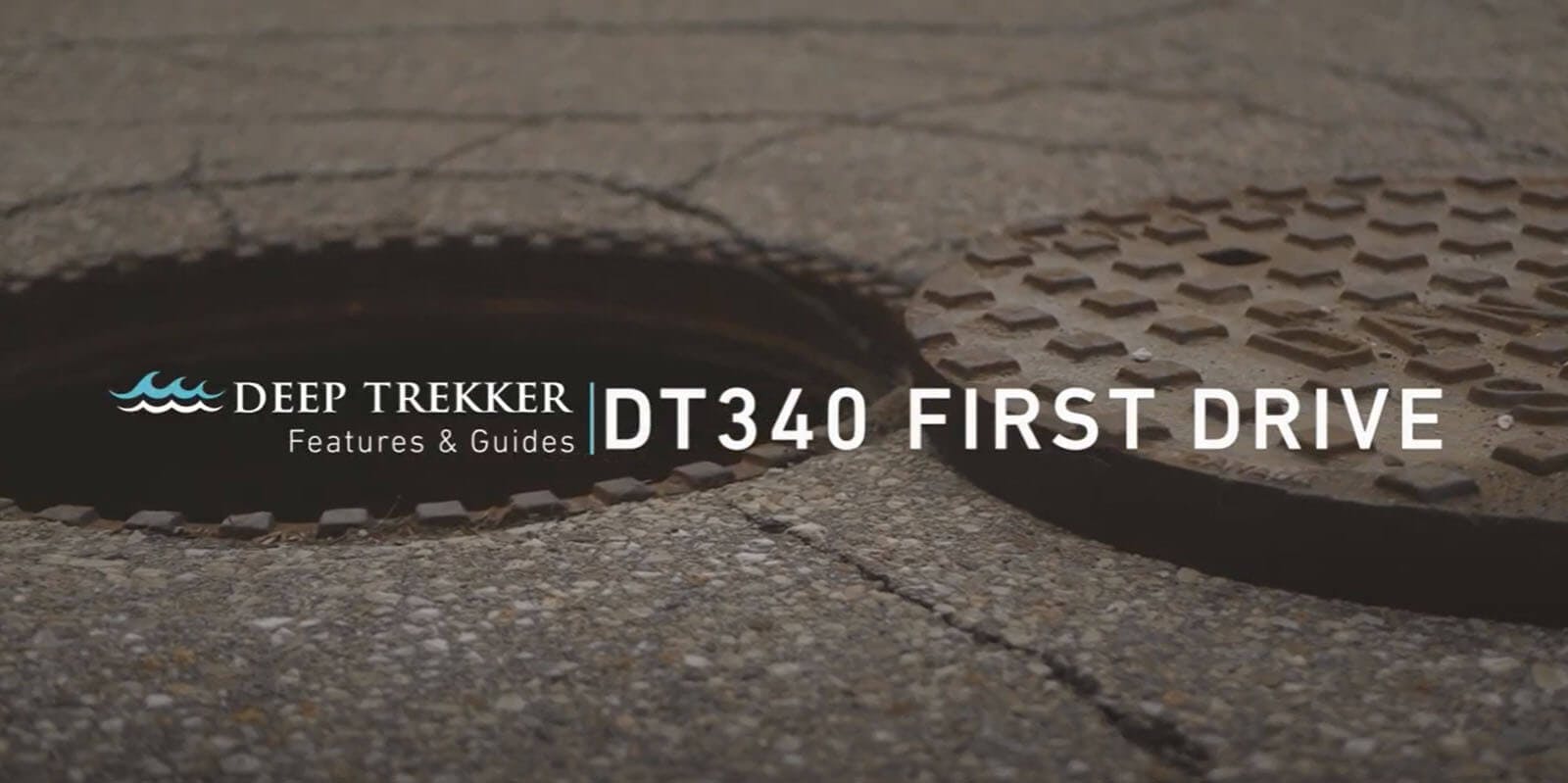 Close up of a manhole in a driveway with the Deep Trekker logo and "DT340 First Drive" written in white.