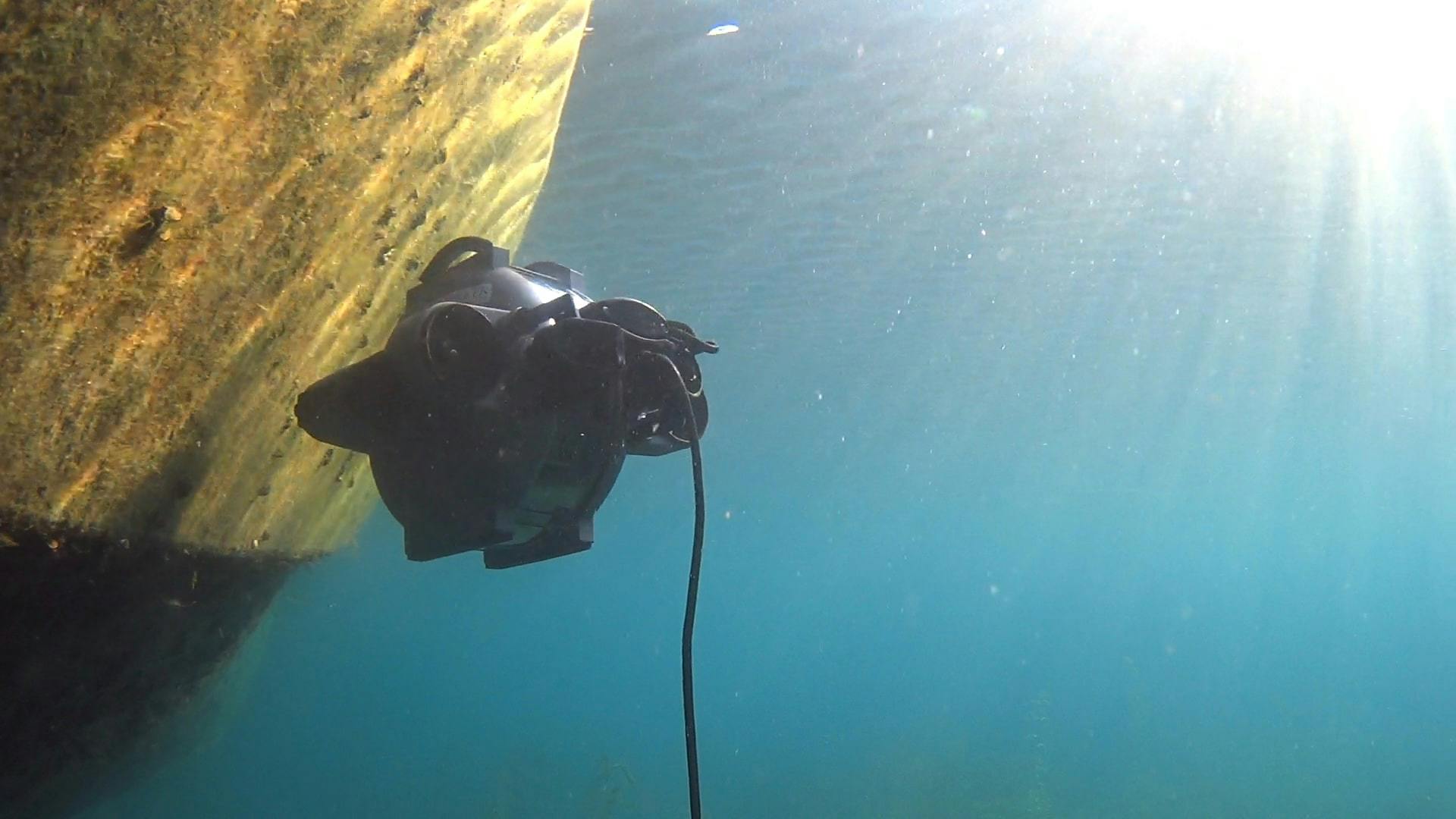 The Deep Trekker DTG3 underwater ROV swimming towards a grey ship hull