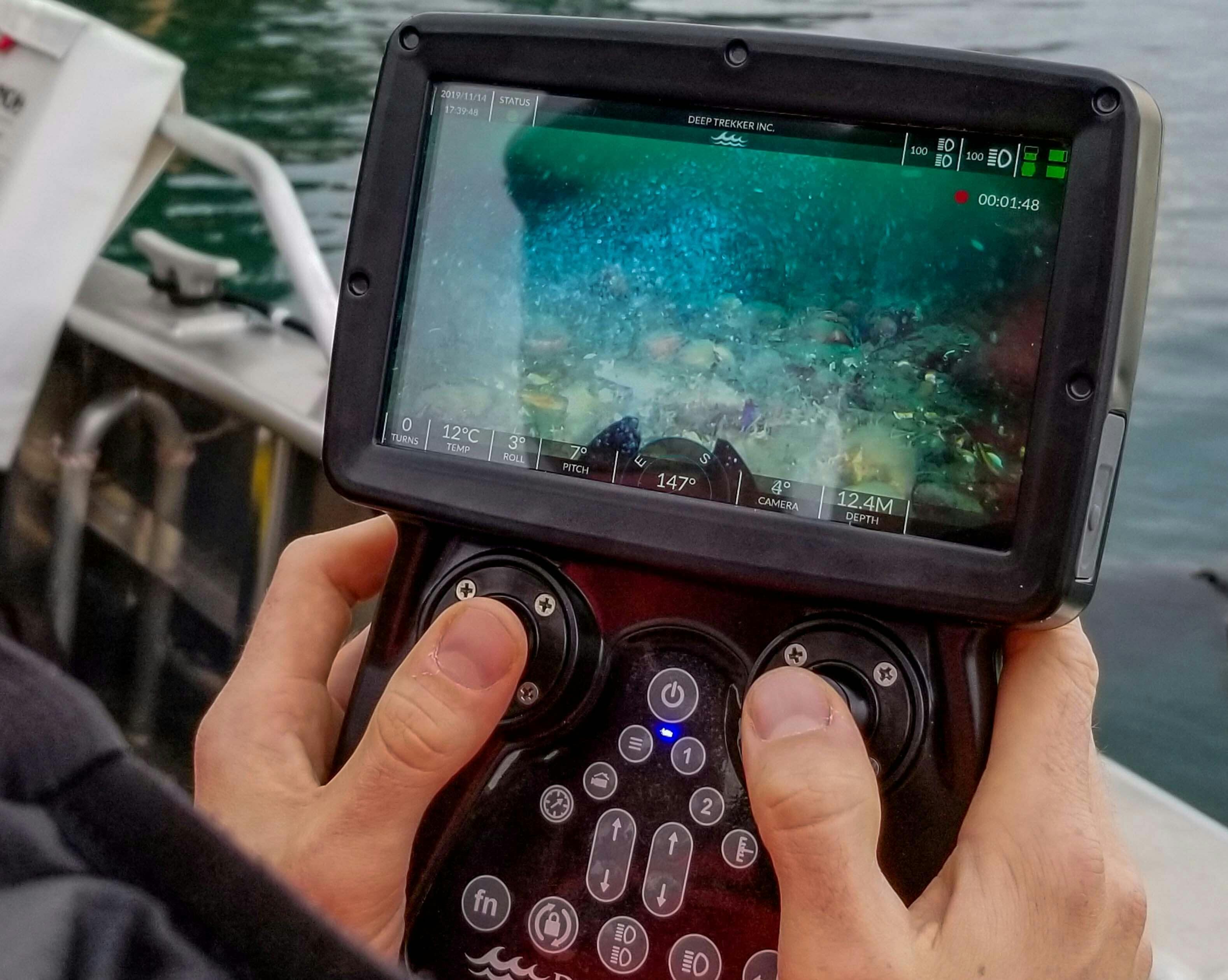 Hands holding ROV controller during an infield update