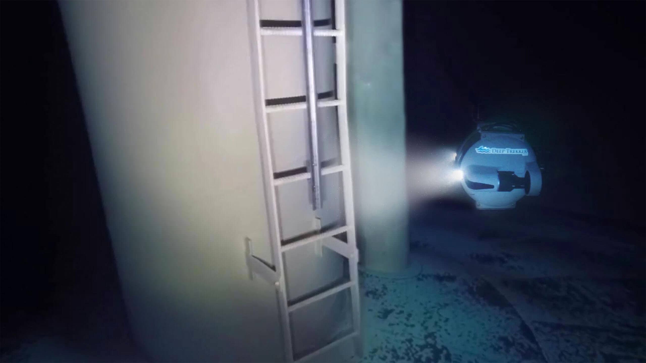 The Deep Trekker DTG3 ROV swimming underwater in a water tank. Vehicle is swimming up to tower and ladder.